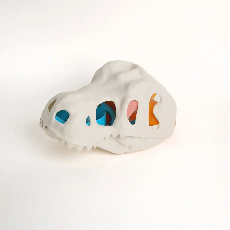 Craniu de dinozaur Woopie cu accesorii colorate depozitate în interiorul setului de nisip.