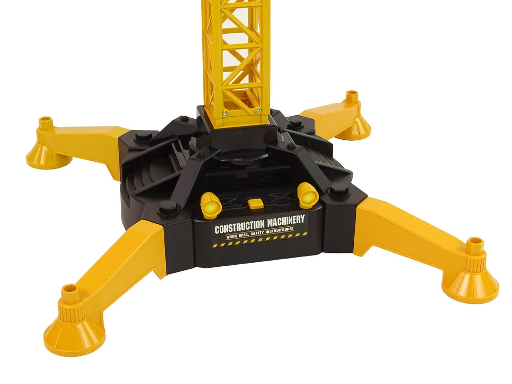Detaliu cu baza stabilă a macaralei turn RC Lean Toys, cu patru picioare de sprijin și corp negru-galben.