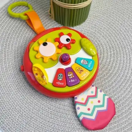 Bufniță interactivă Lean Toys așezată pe covor, cu pianină și coadă foșnitoare.