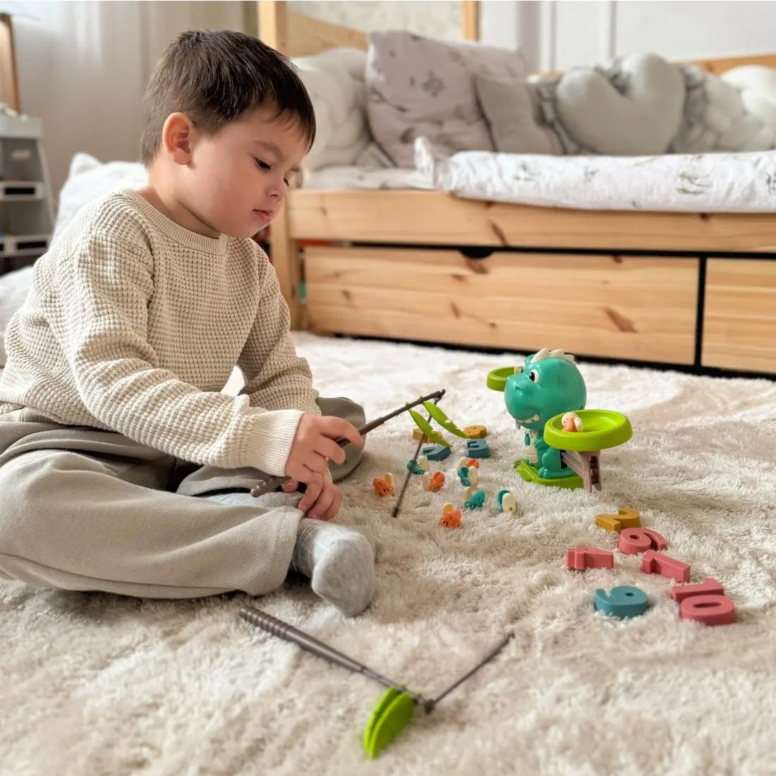 Copil care pescuiește figurine cu jocul educativ Woopie Balanță Dinozaur.