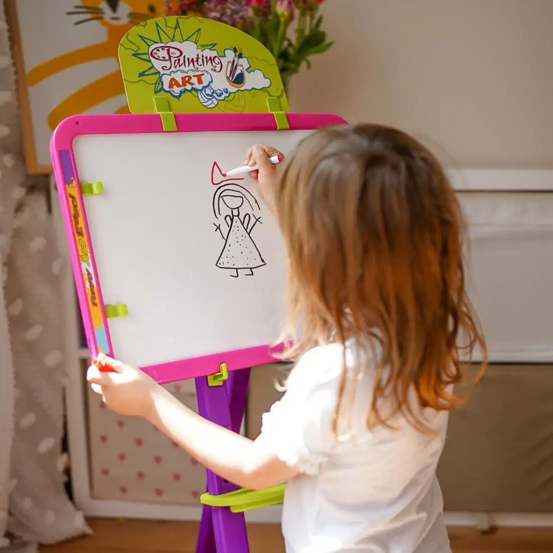 Copil care folosește partea albă a tablei Woopie pentru desen cu marker.