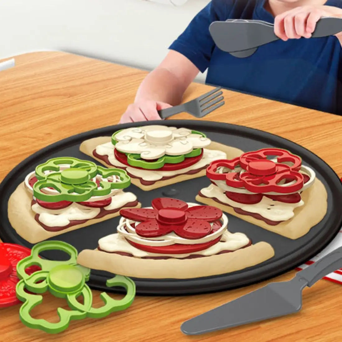 Copil care se joacă cu setul Woopie Pizza Slicer XL, folosind cutterul și furculița pentru joc de rol bucătărie.