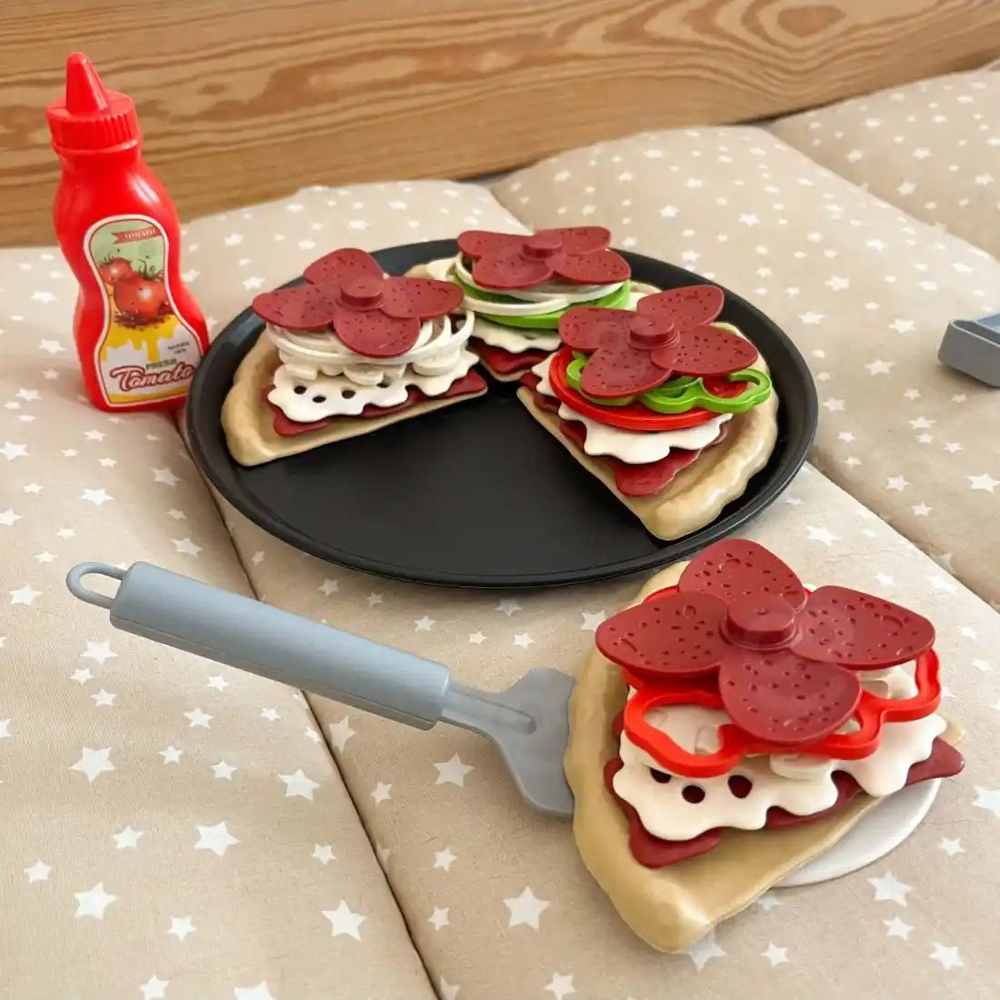Felie de pizza Woopie servită cu spatula, lângă tavă, sos și toppinguri pentru joc de restaurant.