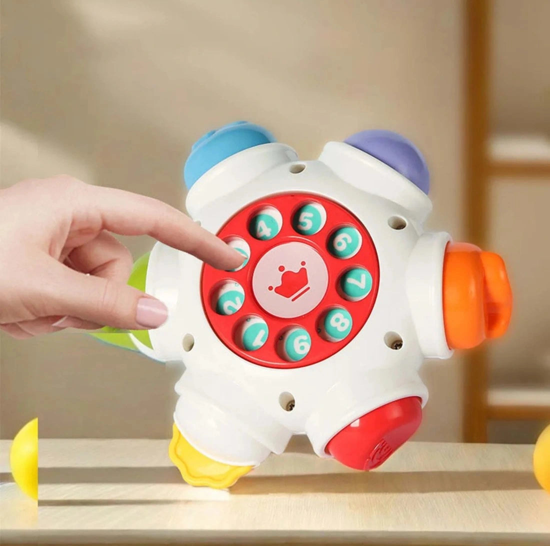 Detaliu cu telefon rotativ și butoane pentru degețele curioase la Woopie Busy Ball.