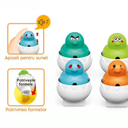 Set Woopie Ouă cu puișori Montessori în cutie galbenă, cu 6 ouă albe, puișori colorați, forme și sunet la apăsare.