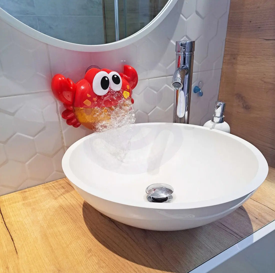 Woopie Bubble Crab montat lângă chiuvetă, generând spumă pufoasă cu ventuzele pe faianță.