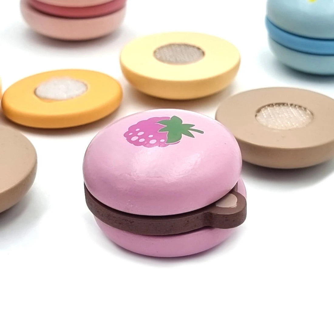 Closeup cu macaron roz PolarB Viga cu model căpșună, umplutură maro și sistem de prindere cu scai.