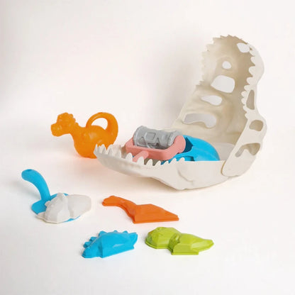 Accesoriile setului de nisip Woopie Dinozauri pe fundal alb, cu craniu, forme, lopățică și rolă.