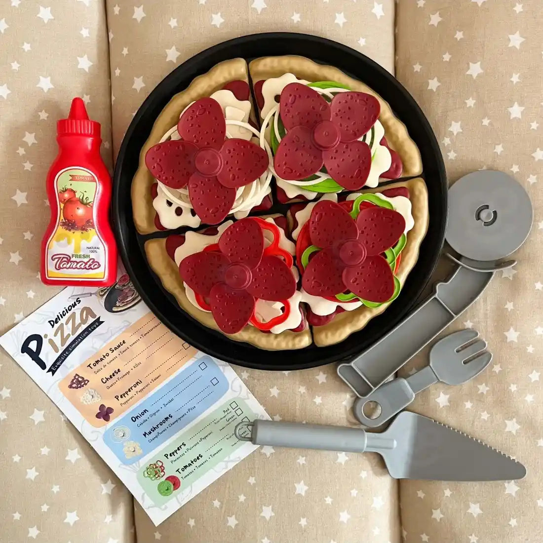 Set Woopie Pizza cu meniu, sos, cutter, spatulă și furculiță, așezat lângă pizza pe tavă.