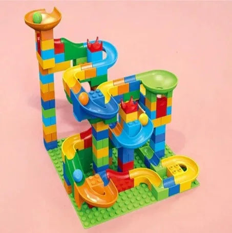 Model vertical de pistă cu bile Woopie Marble Run pe fundal roz, cu pâlnii și coborâri suprapuse.